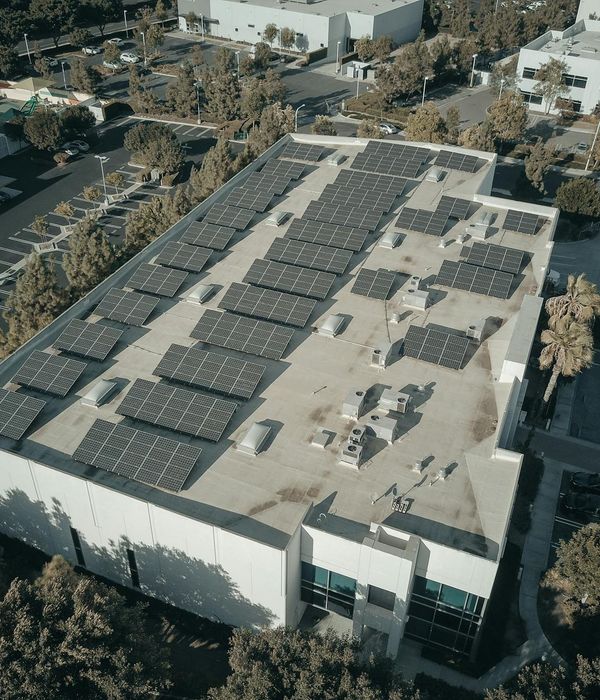 Large scale solar photovoltaic array installation with inverter equipment on commercial rooftop